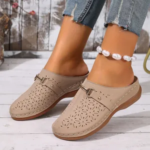 Close-up of women's casual beige clogs with floral hollow-out design and buckle strap