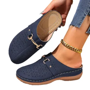 Women's navy blue platform mules featuring cutout floral patterns and metal buckle strap