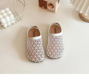 Detalle de sandalias cerradas de malla transpirable crema para niñas con suela blanda