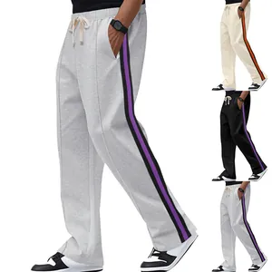 Detailed view of men's flared sweatpants with contrast side stripes in multiple colors.