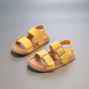 Detailed view of yellow children's beach sandals with double buckle straps and soft brown soles.