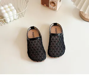 Detalle de sandalias de malla negra transpirables para niños con suela blanda