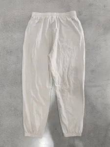 Detail view of men's loose linen joggers in light beige with elastic waistband
