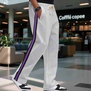 High street men's grey flared sweatpants with purple side stripes in a mall setting