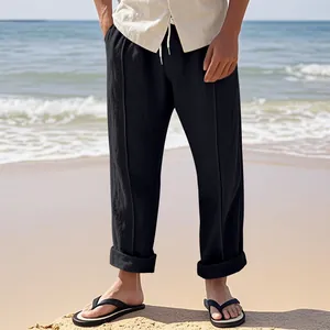 Locker sitzende schwarze Leinenhose für Herren in sommerlicher Strandatmosphäre