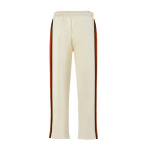 Full front view of cream flared sweatpants with orange and brown side stripes