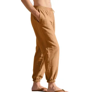 Side view detail of men's loose khaki linen pants with drawstring and tapered ankles