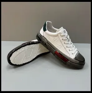 Detailed view of white men's fashion sneakers featuring unique cross-embroidery.