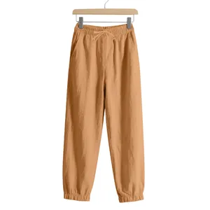 Close-up of men's ginger linen joggers with drawstring and elastic waist.