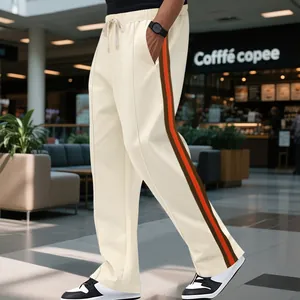 Side view of cream men's flared sweatpants with orange and brown side stripes detail.