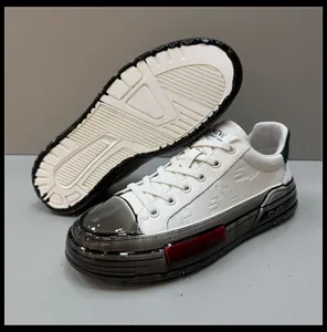 Detailed view of men's casual white leather sneakers with textured rubber outsole