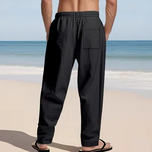 Rückansicht einer schwarzen lockeren Sommer-Leinenhose für Herren am sonnigen Strand