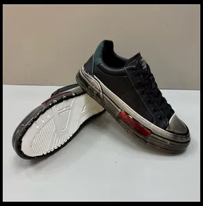 Detailed close-up of men's black fashion sneakers with metallic silver and red accents