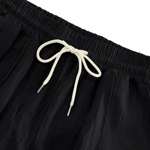 Detaillierte Nahaufnahme der schwarzen Leinenhose mit Gummibund und weißem Kordelzug