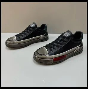 Side view detail of men's black leather shoes with metallic silver sole and red insert.