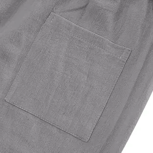 Makro-Detailansicht einer quadratischen Tasche an einer grauen Leinenhose mit Stoffstruktur.