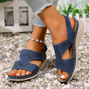 Detailweergave van marineblauwe uitgesneden zomerse wedgesandalen met een open teen design.