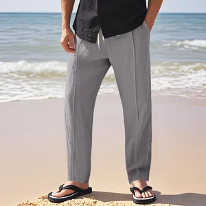 Vollansicht der lässigen grauen Leinenhose für Herren mit Kordelzug am Strand