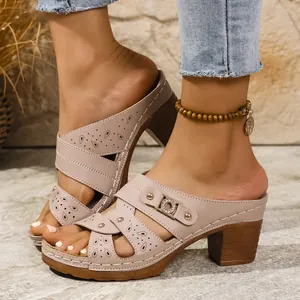 Close-up of beige thick-soled peep-toe mules with hollow-out patterns and rhinestone buckles