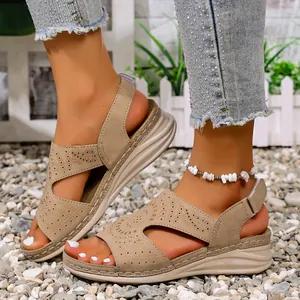 Detailopname van beige zomerse platte sandalen met een trendy opengewerkt design.