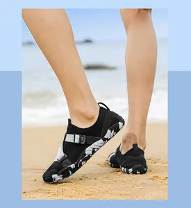 Dettaglio di scarpe da scoglio nere traspiranti con suola antiscivolo sulla sabbia