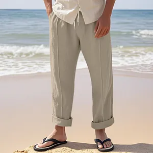 Leichte khakifarbene Herren-Leinenhose mit Kordelzug in einer sonnigen Strandumgebung.