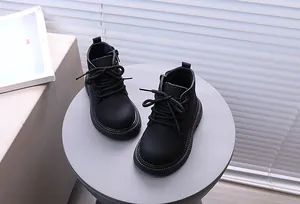 Nahaufnahme schwarzer Kinder-Martin-Boots im britischen Stil mit Reißverschluss
