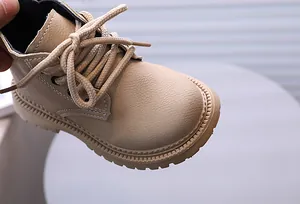 Detailansicht der beigen Kinder-Schnürstiefel mit Lederstruktur und Kontrastnähten.