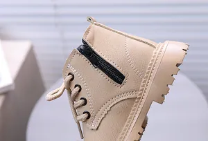 Nahaufnahme beiger Kinder-Martin-Stiefel mit Reißverschluss und Steppnaht-Details.