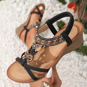 Close-up of bohemian wedge sandals with butterfly and heart rhinestone charms