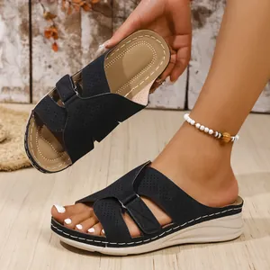 Stylish black wedge sandals with perforated cross straps and comfortable wedge sole for summer