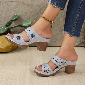 Detail shot of light blue laser-cut heart pattern sandals with retro block heels