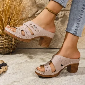 Close-up of pink peep-toe platform mules with laser-cut patterns and block heels.
