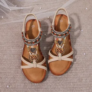 Detailed view of bohemian wedge sandals featuring rhinestone butterfly ornaments
