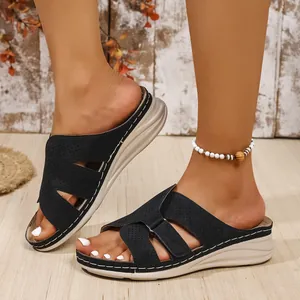 Detail of black wedge sandals with cutout design and comfortable thick sole.