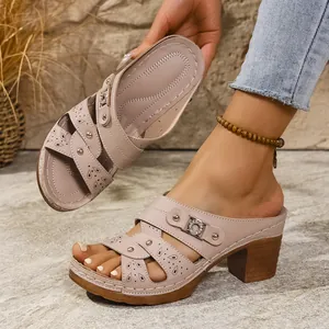 Close-up of pink chunky heel platform sandals with hollow-out design and studs
