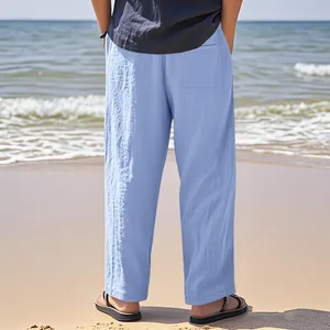 Rückansicht einer bequemen, hellblauen Leinenhose für Herren am sonnigen Strand.