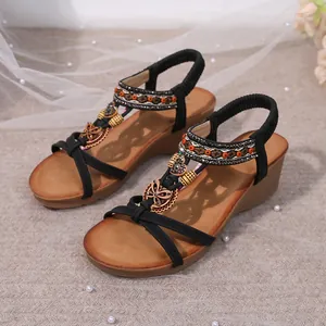 Detailed view of Bohemian wedge sandals with beaded rhinestones and butterfly charms