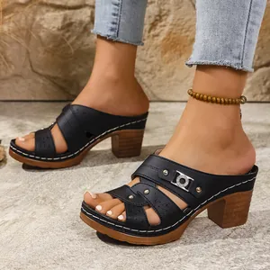 Detail shot of women's black platform peep-toe sandals with cutout designs and a wooden heel.
