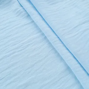 Macro view of light blue crinkled fabric texture for casual men's summer shirt.