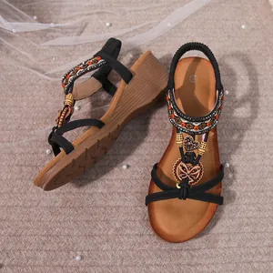 Close-up detail of bohemian wedge sandals featuring intricate beadwork and butterfly charms