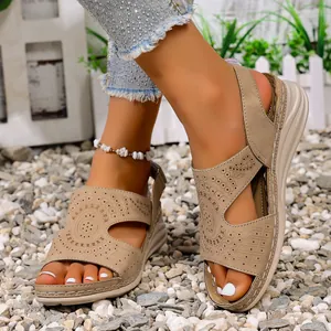 Gedetailleerd overzicht van beige platte sandalen met uitgesneden motief en peep toe.