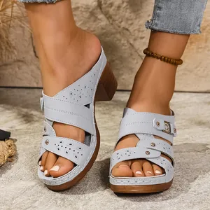 Close-up shot of light blue platform sandals featuring laser-cut patterns and chunky heels