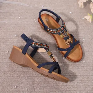 Detail view of navy bohemian wedge sandals with decorative beads and heart charms