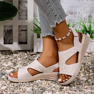 Gedetailleerde weergave van gebroken witte zomersandalen met lasergesneden gaten