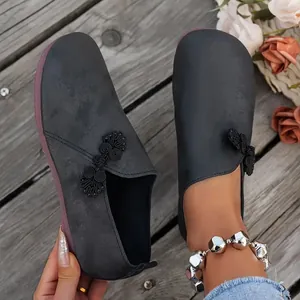 Λεπτομερής άποψη μαύρων vintage loafers με παραδοσιακό κινεζικό κόμπο σχέδιο