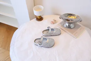 Vue détaillée des sandales tressées argentées pour filles avec motif ajouré et boucle