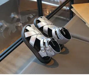 Detalle de sandalias romanas plateadas para niñas con acabado metálico y hebillas.