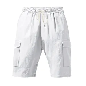 Dettaglio di pantaloncini cargo in lino bianco con coulisse e tasca laterale.