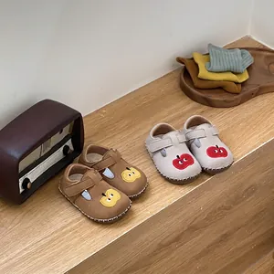 Zapatos de bebé con dibujos de manzanas en escalera de madera con decorado